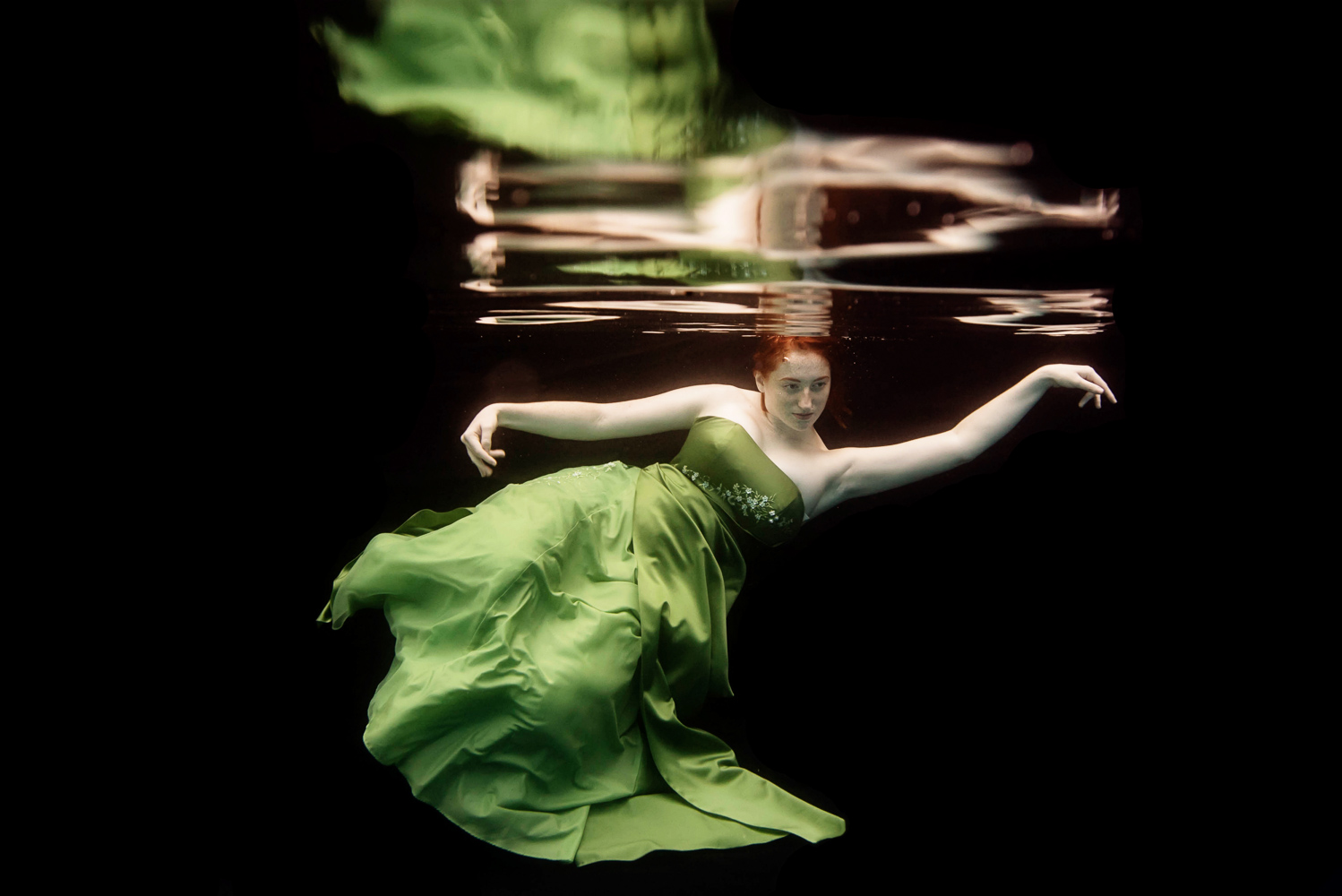 underwater fashion shoot with a woman with red hair wearing a green dress
