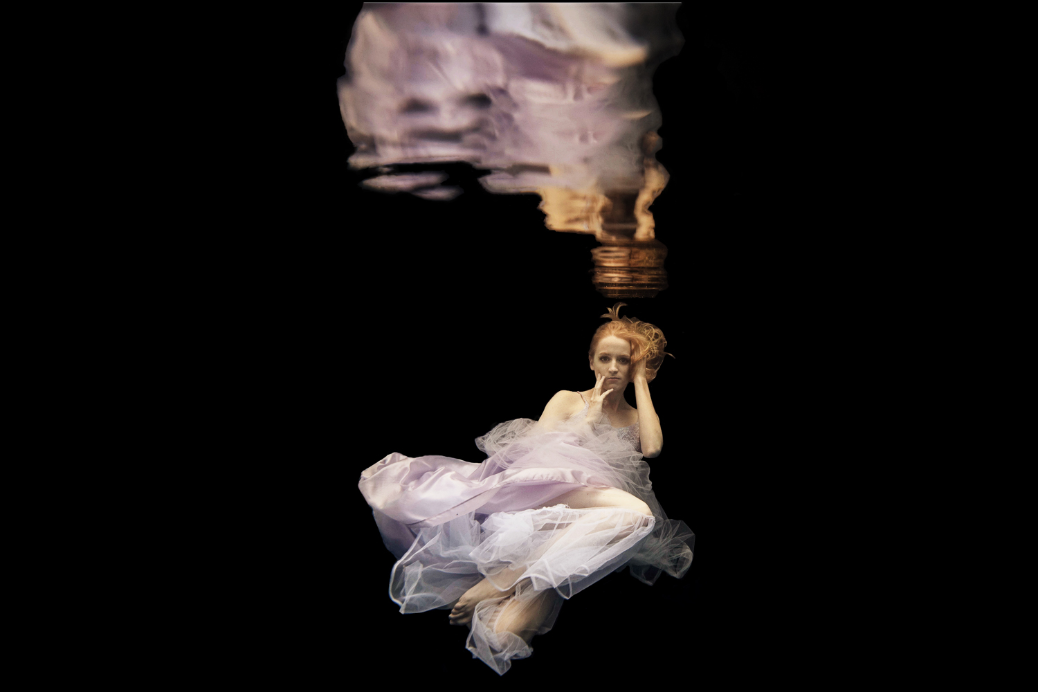 blond girl in a purple dress underwater