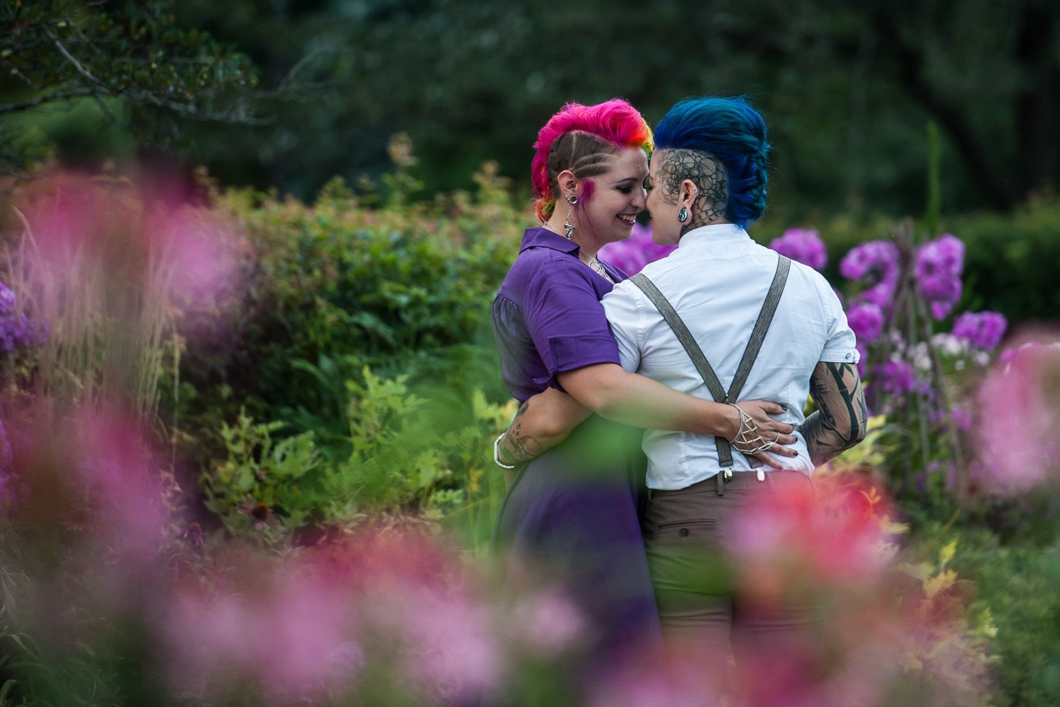 same sex couple with blue and pink hair in the rose garden at Lake Harriet during their engagement session