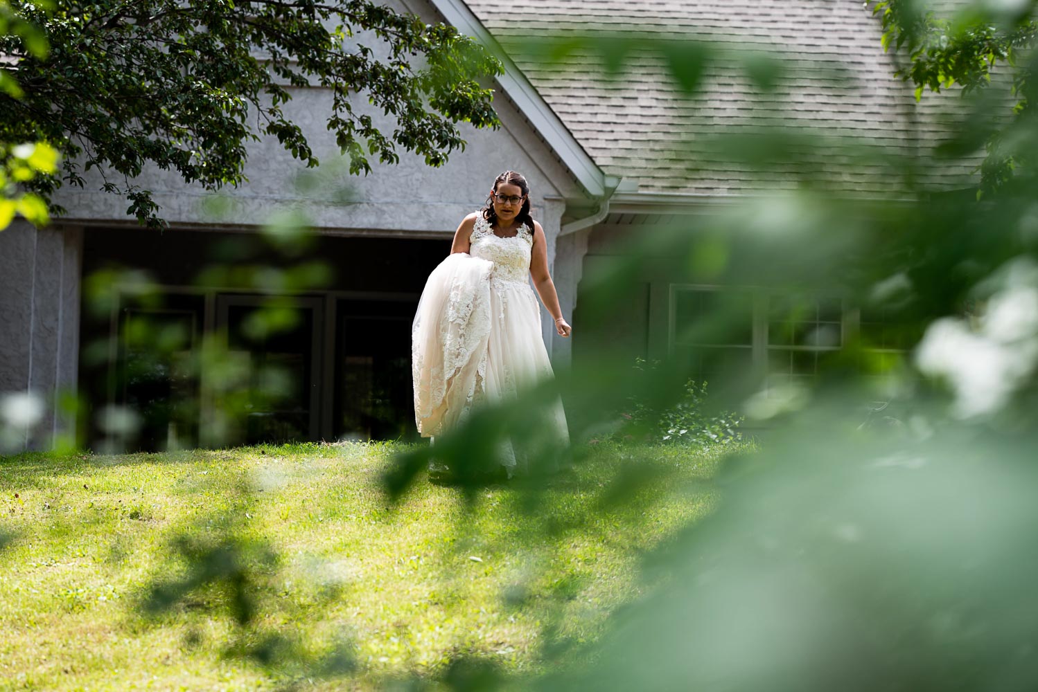 bride walking to meet the groom for their first look before their summer wedding at their home