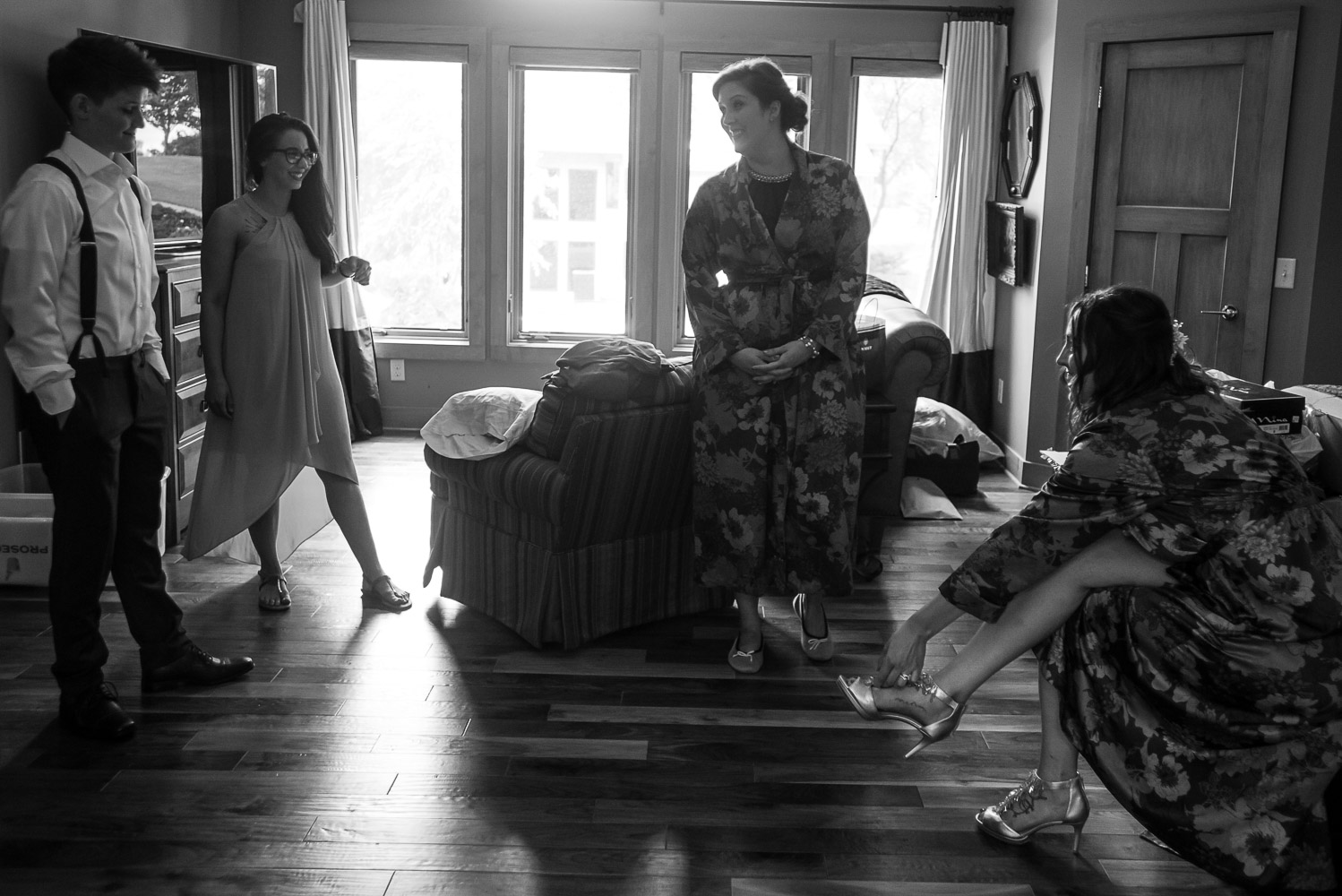 bride getting help with her shoes and dress