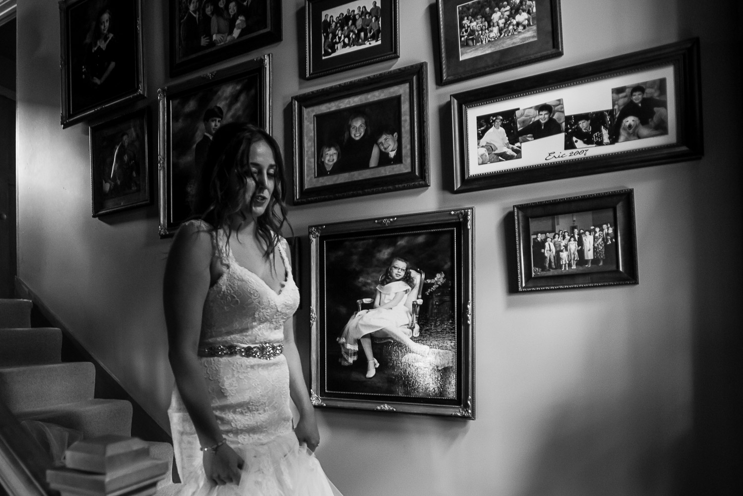 bride walking down the stairs at her parents home with portraits behind her on the wall in Victoria Minnesota
