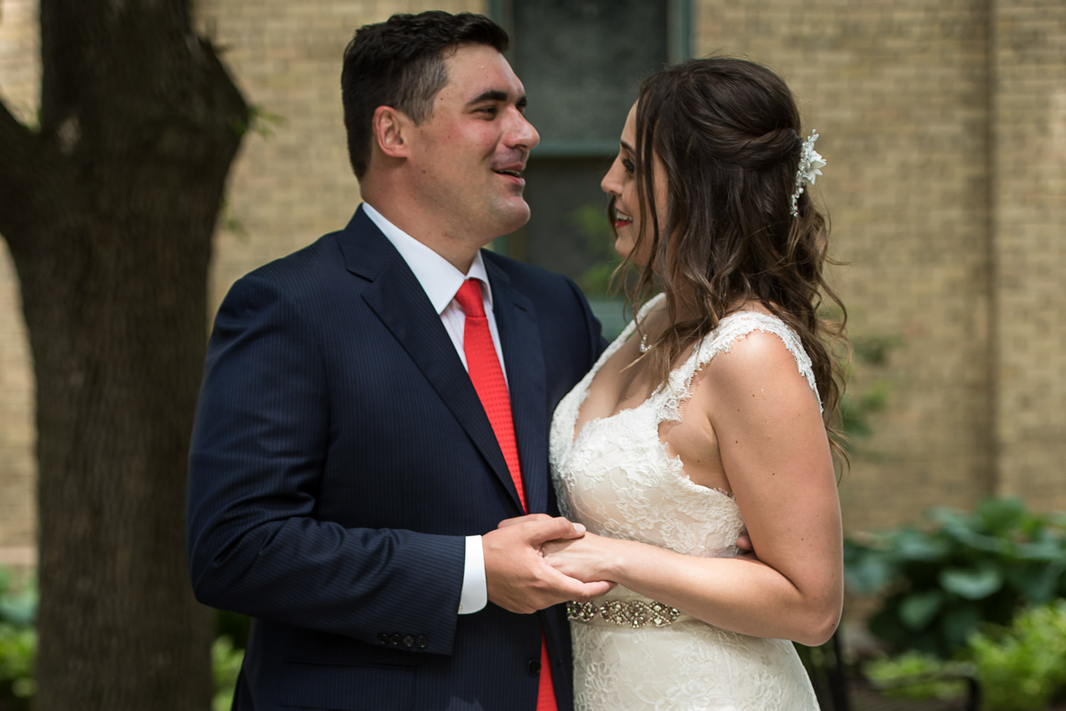 bride and groom holding hands in front of the church before their wedding atSt. Victoria Catholic Church