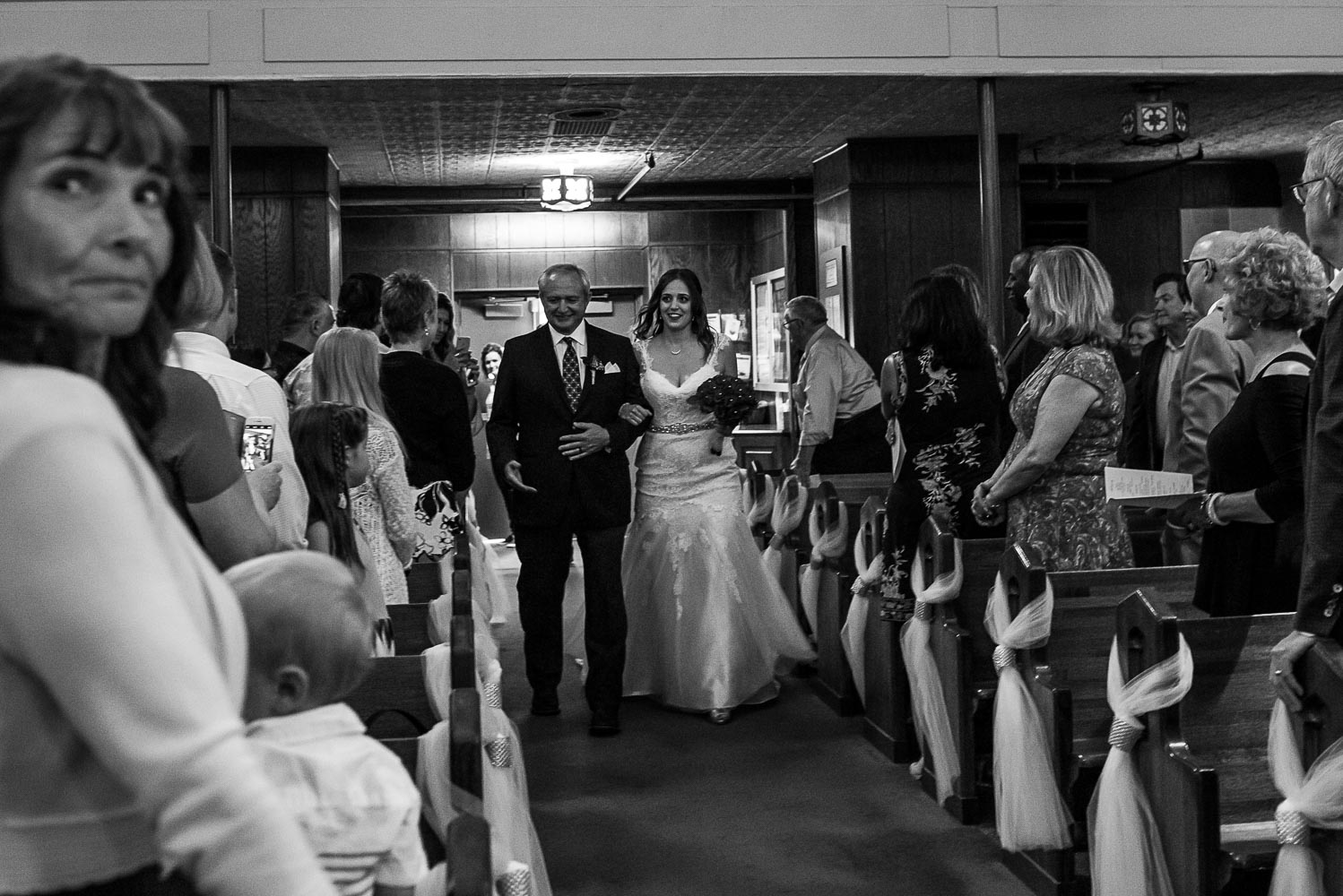 father walking his daughter down the aisle at St. Victoria Catholic Church in Minnesota