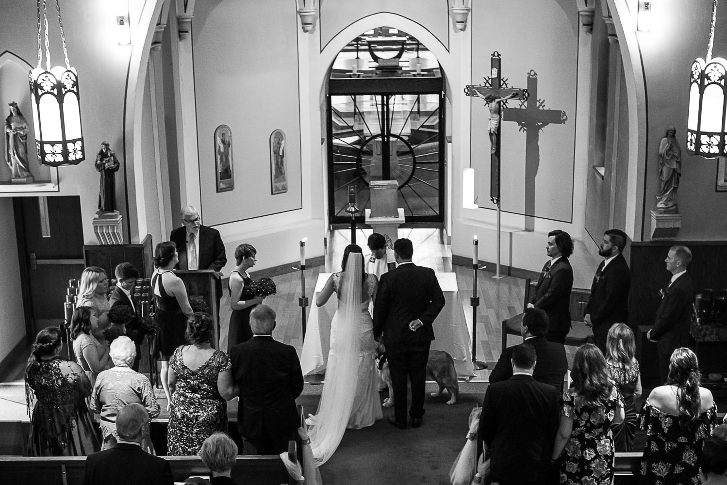 bride and groom standing at the alter with the priest during the ceremony at St. Victoria Catholic Church in Minnesota