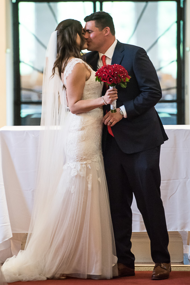 bride and groom kissing for the first time after the wedding ceremony at St. Victoria Catholic Church