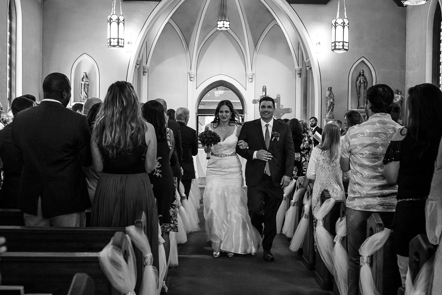 bride and groom during the recessional after the wedding ceremony at St. Victoria Catholic Church