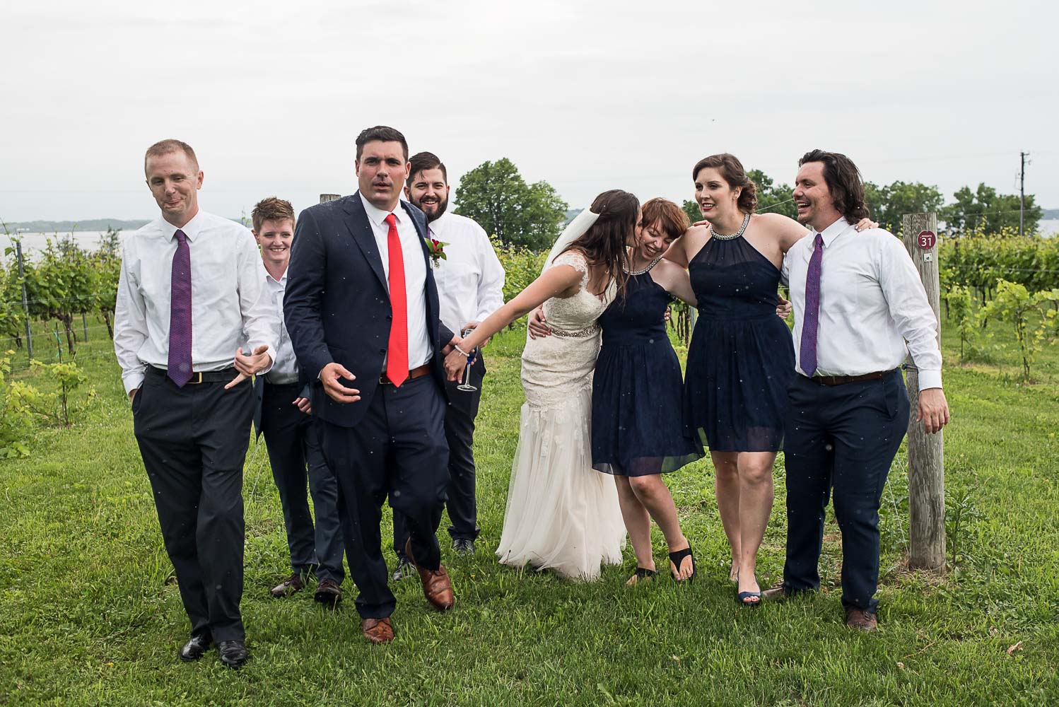 casual wedding party playing in the rain at the Winery at Sovereign Estate