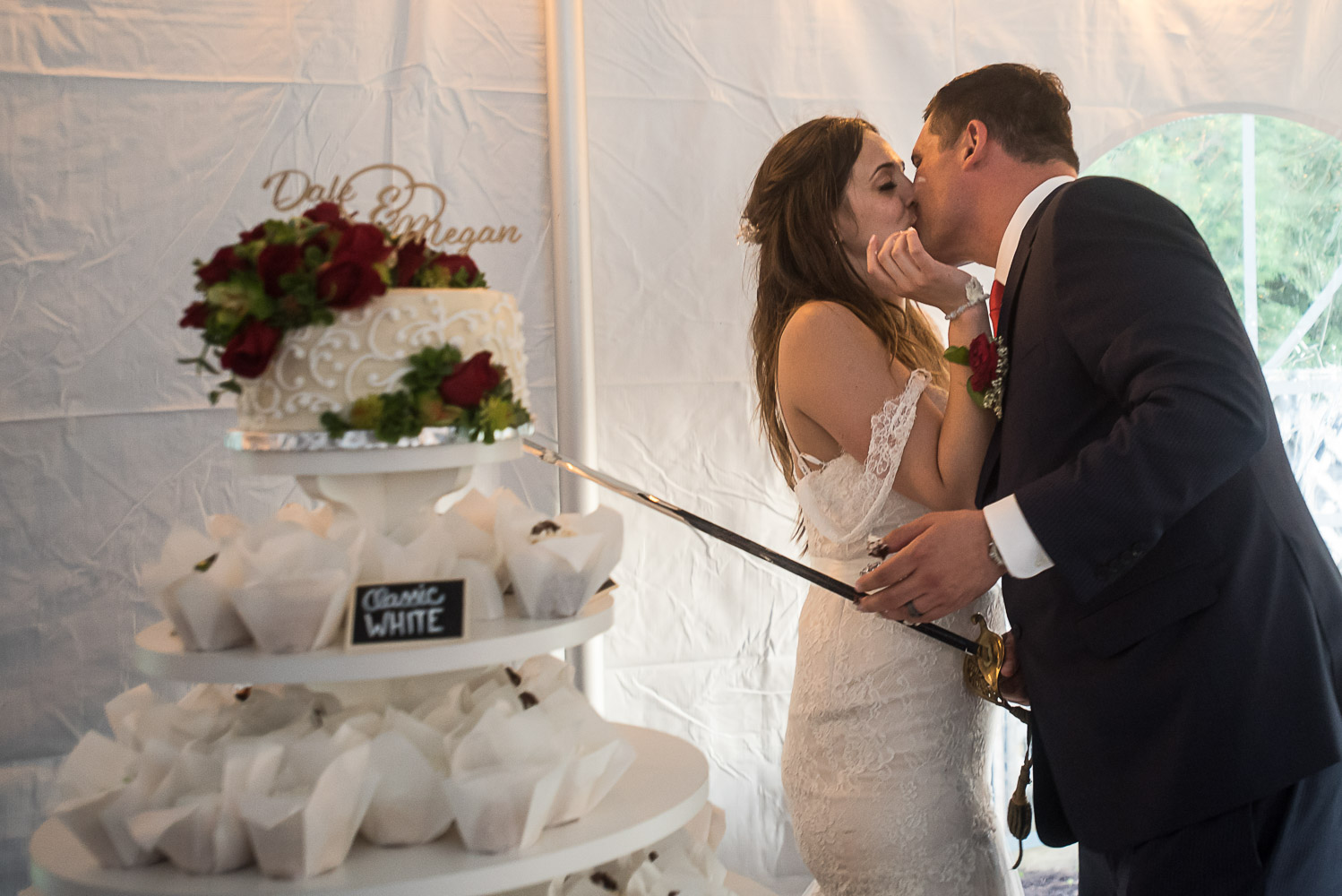 bride and groom kissing in front of the cake after they cut it at their wedding reception at bride and groom laughing while sitting at dinner at their wedding reception at the Winery at Sovereign Estate