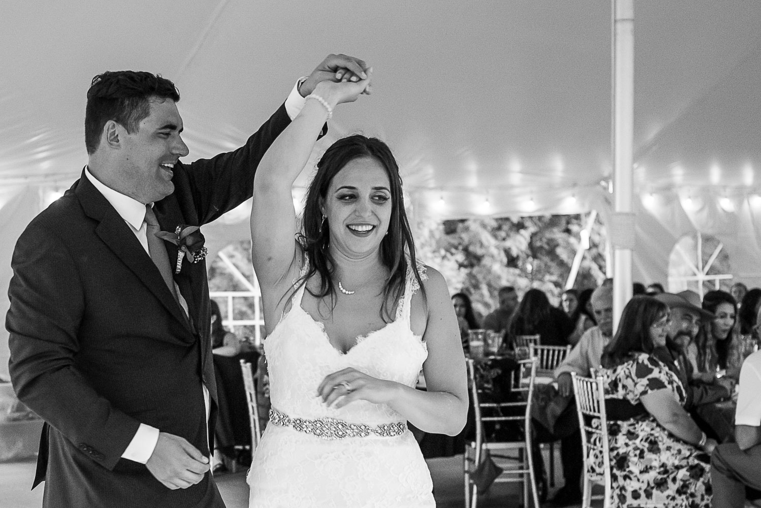 groom twirling bride while doing their first dance at their reception at bride and groom laughing while sitting at dinner at their wedding reception at the Winery at Sovereign Estate