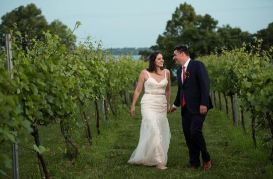 bride and groom walking in together in a vineyard holing hands at the Winery at Sovereign Estate