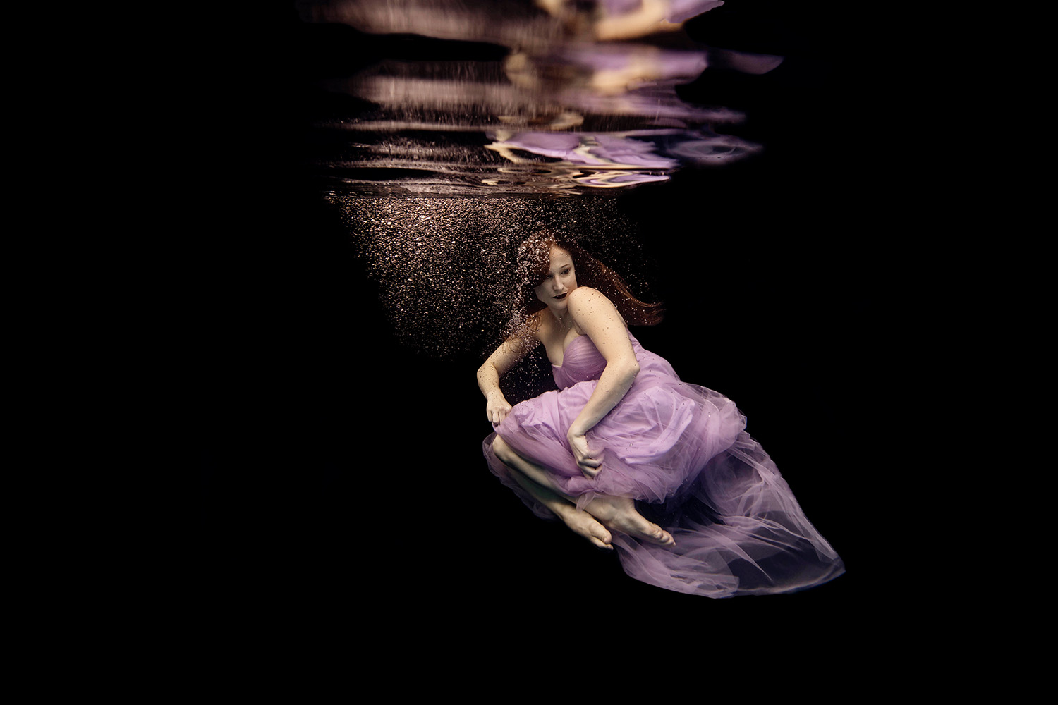 woman in a purple dress underwater