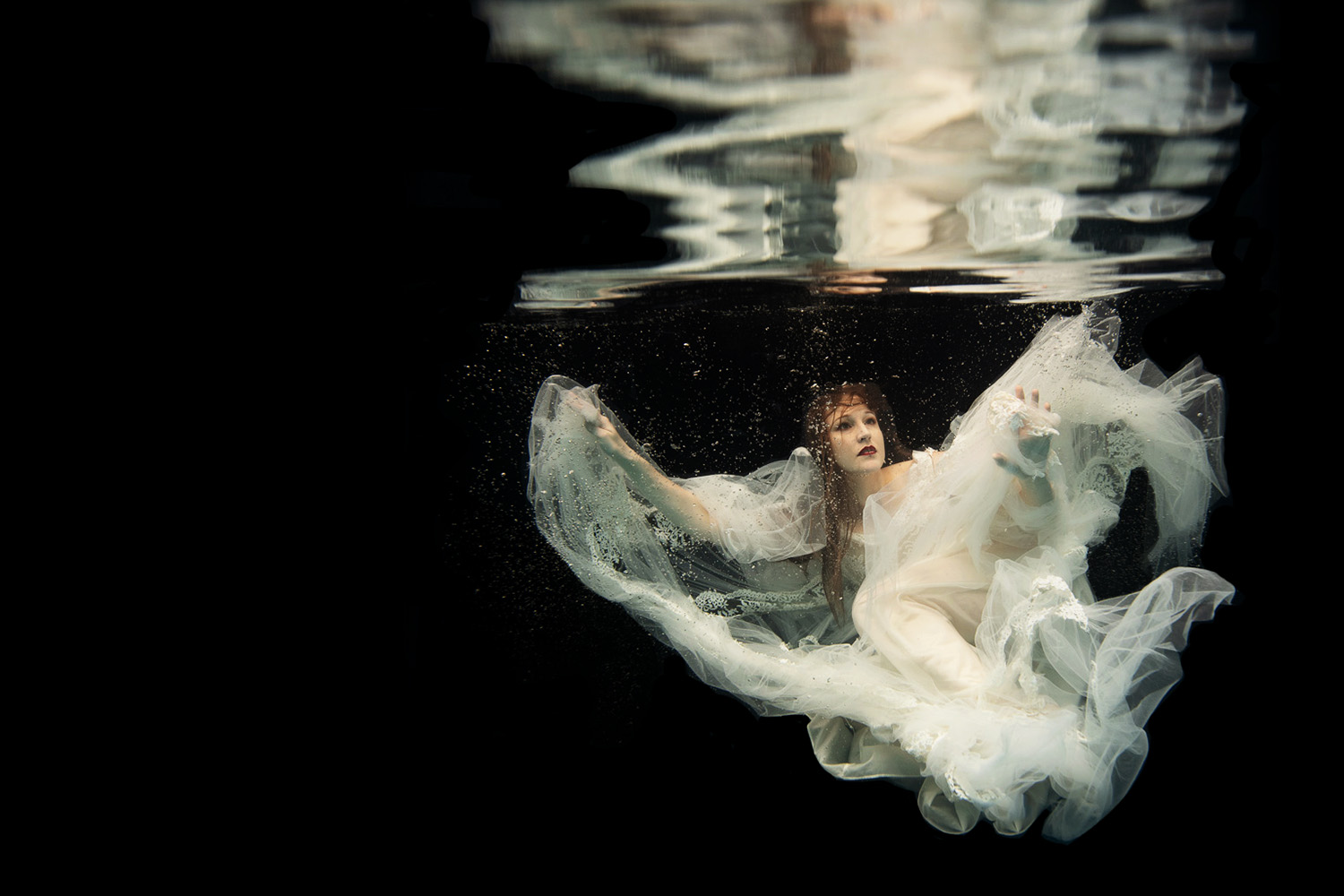 woman underwater in a vintage lace wedding dress