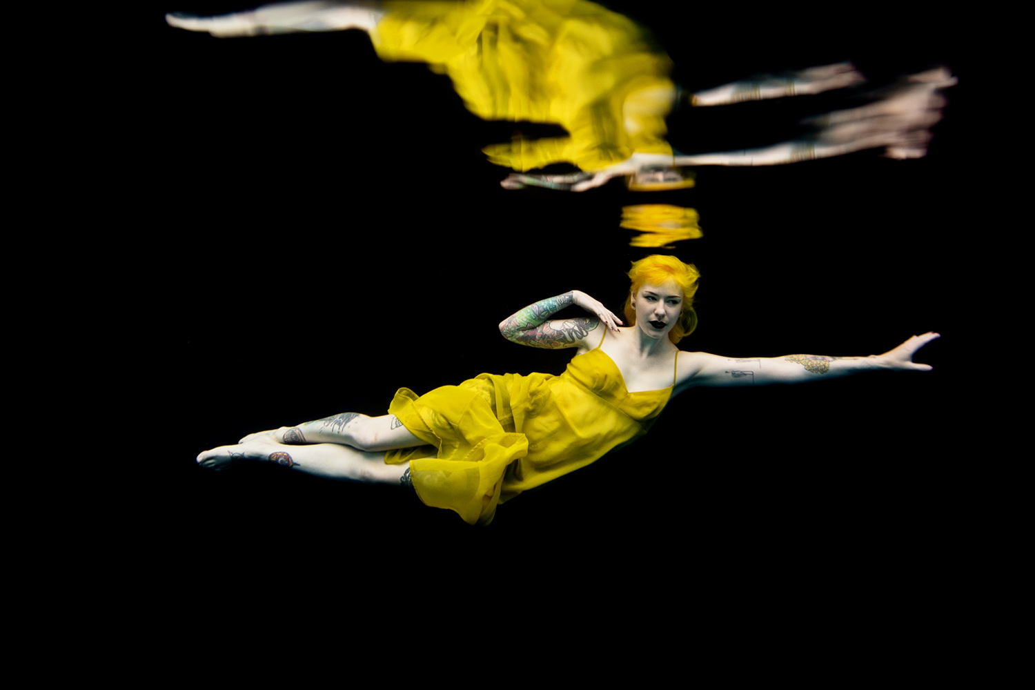 woman with yellow hair wearing a yellow dress underwater