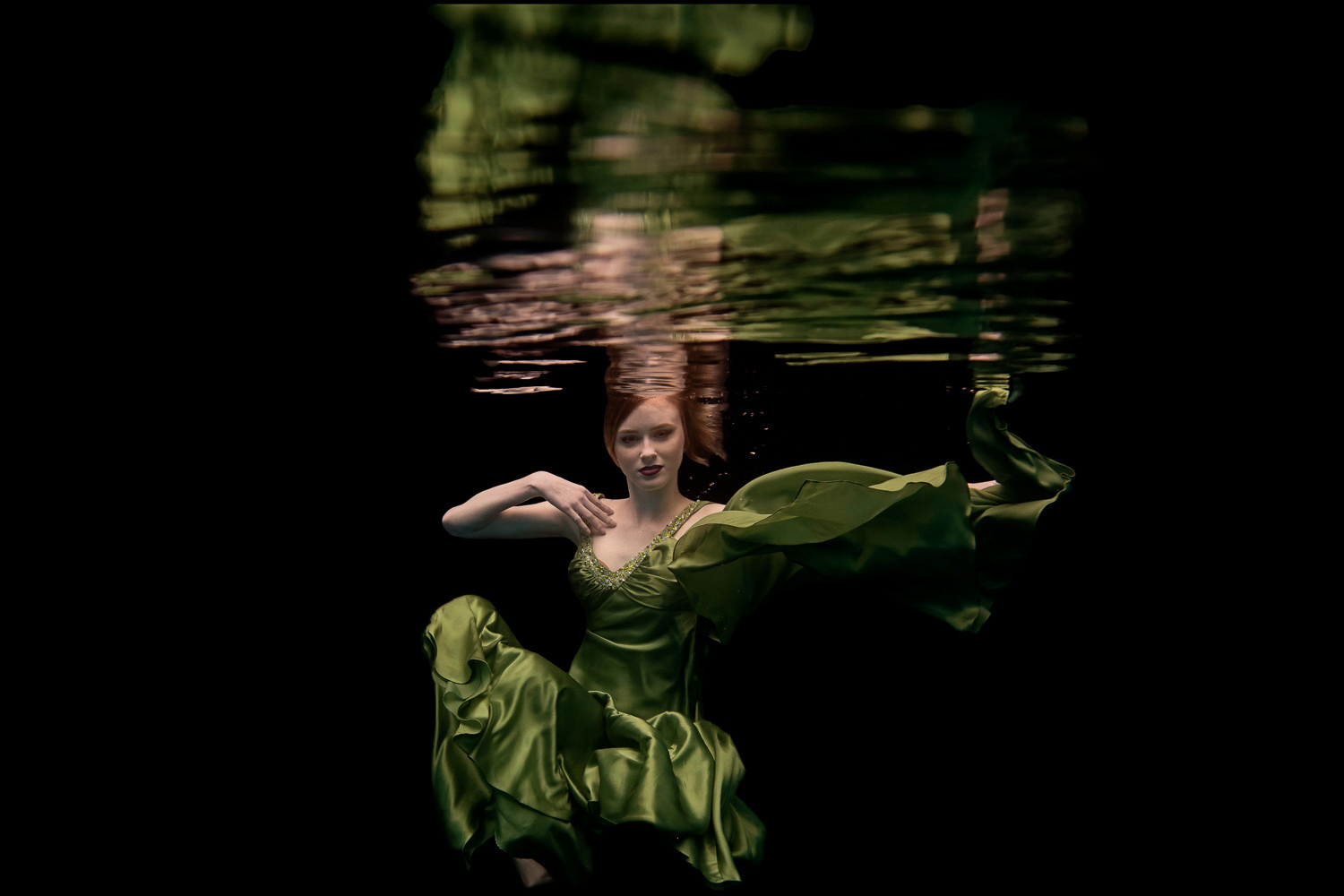 girl in a green dress with a long train underwater