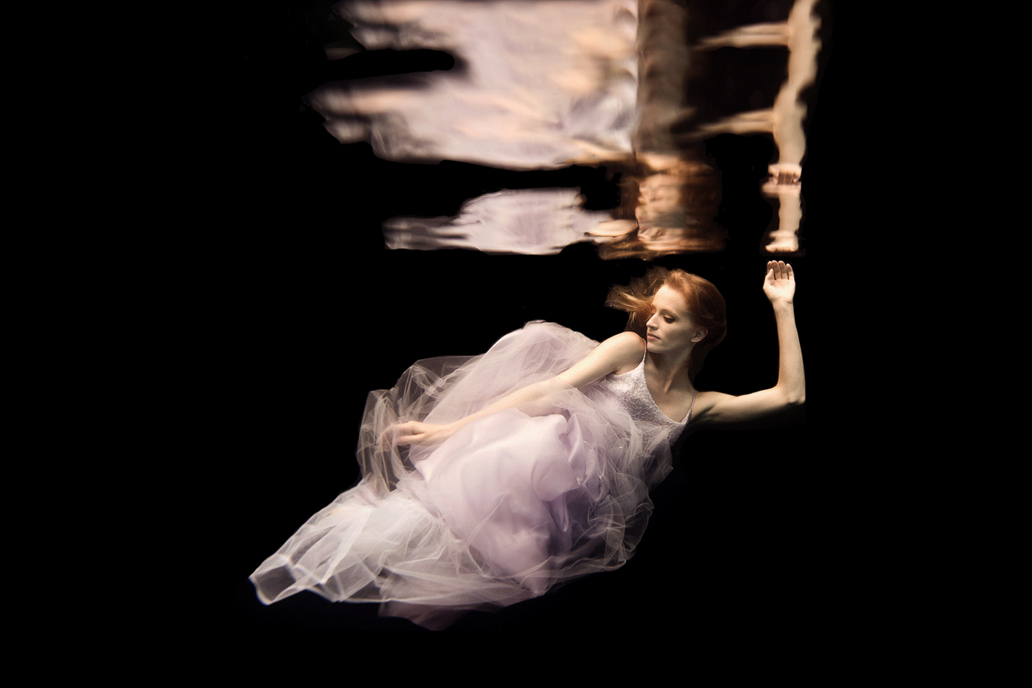 blond woman wearing a pink dress underwater