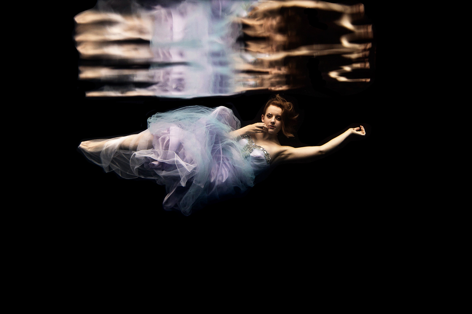 girl wearing a pink and purple dress underwater in Minnesota