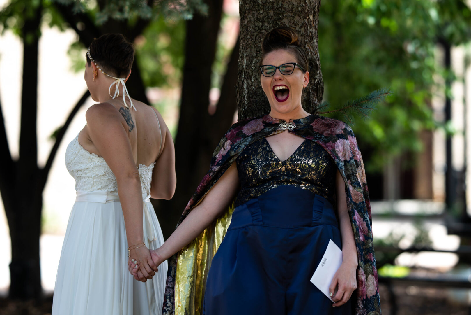 Brides hold hands in excitement prior to first look before wedding ceremony.