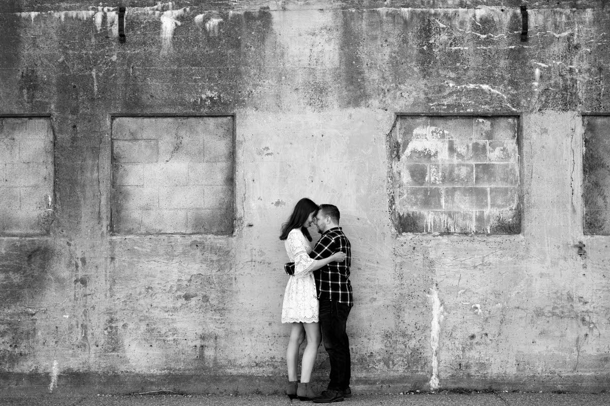 A couple with their arms around each other and their foreheads touching