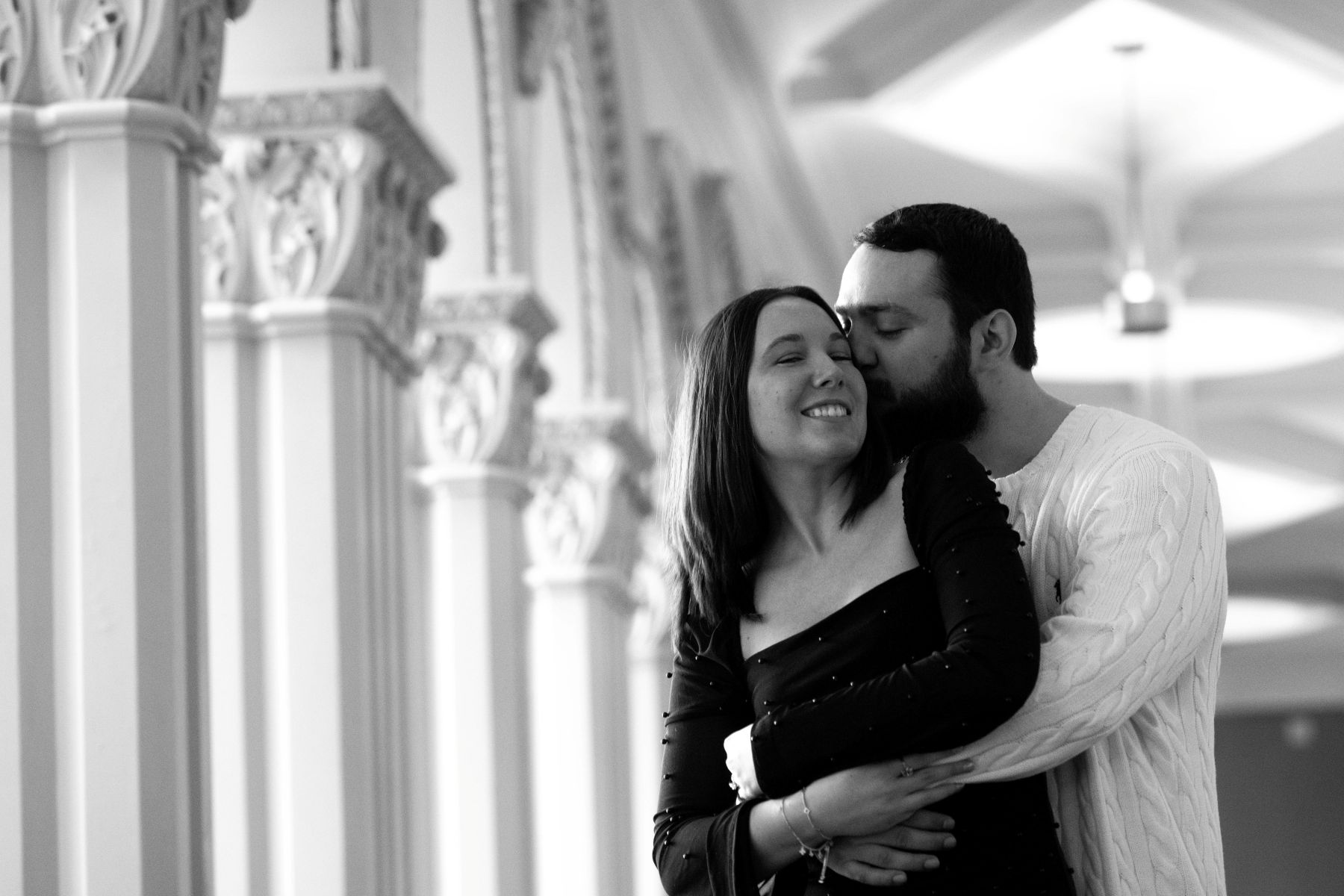 a couple embracing each other taking engaement photos inside of landmark center