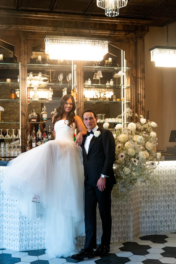 a couple posing in front of the bar in Le VENERÉ taking wedding photos